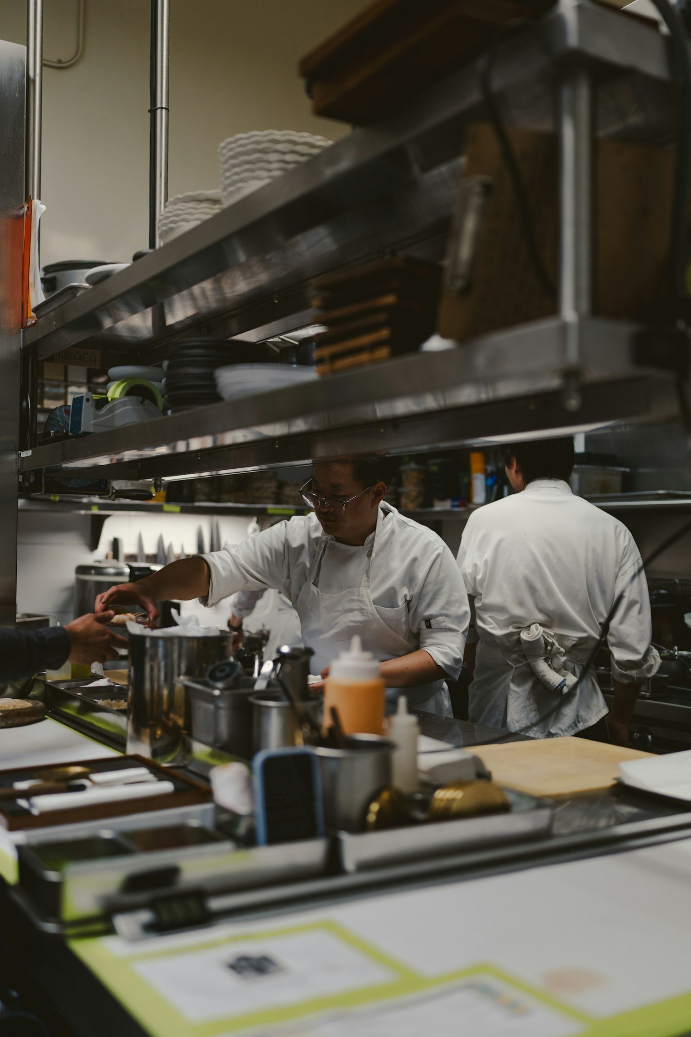 Kitchen team in whites working a commercial cooking line