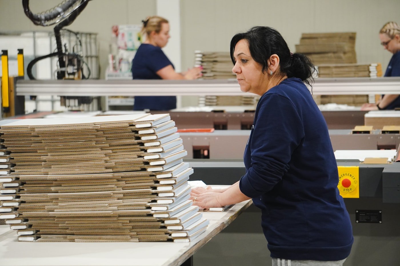 Team handling flat-packed packaging in a production facility